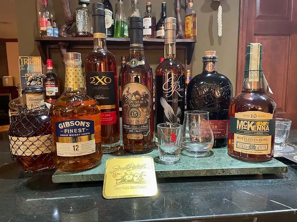 A selection of bourbon bottles and tasting glasses arranged on a bar counter.