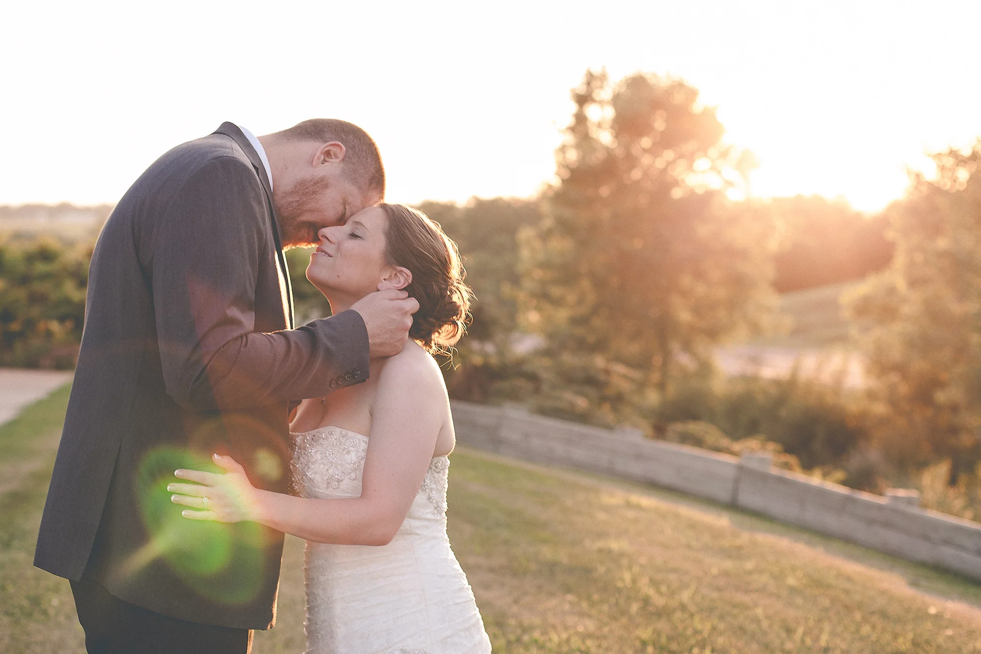 Bride and groom embracing at sunset