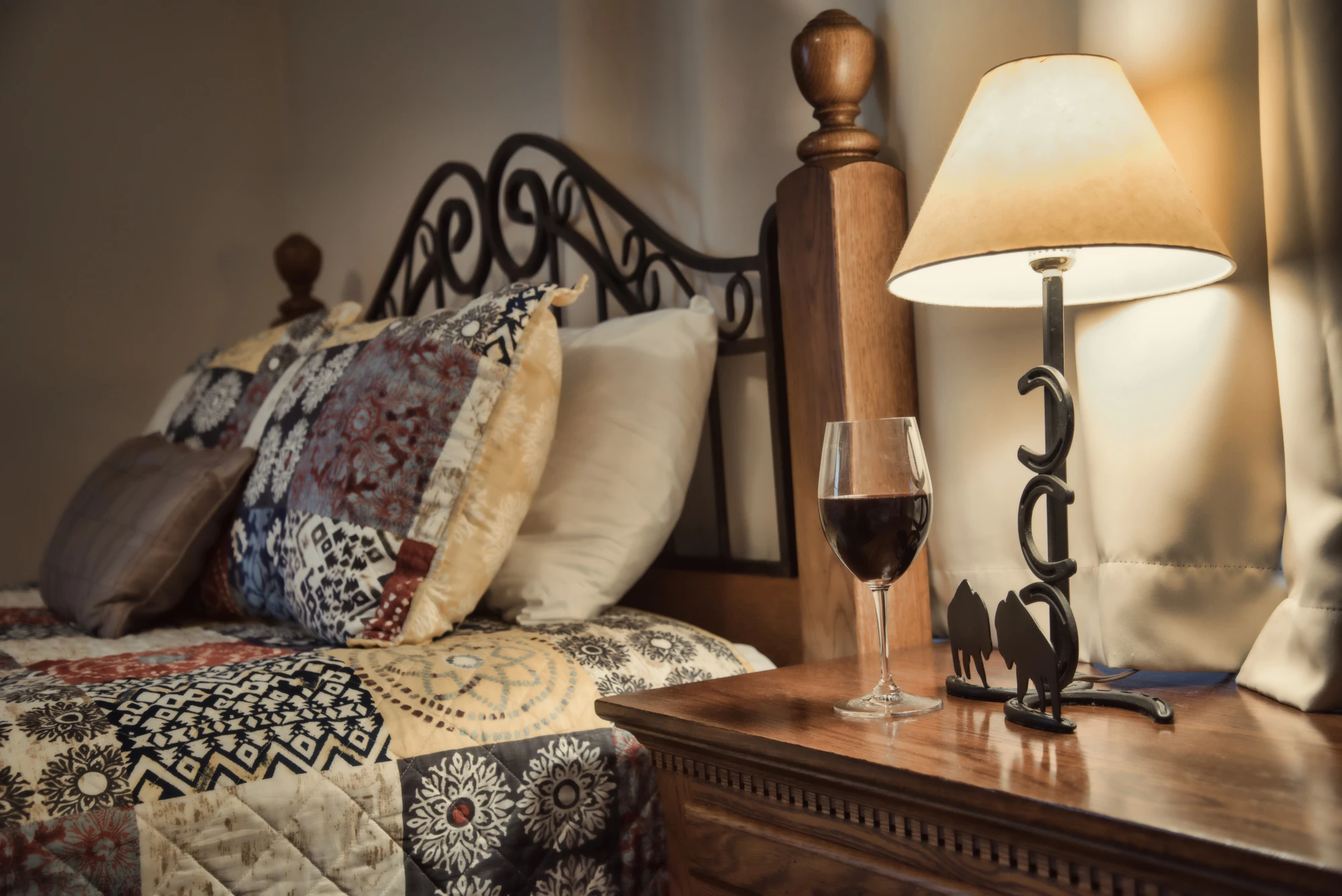 Cozy bed with wine glass at Valiant Vineyards Bed and Breakfast